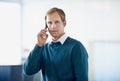 Keeping connected with clients. a handsome young businessman using in cellphone in the office.