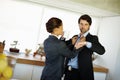 Keeping an eye on the time. Attractive woman fixes her husbands collar while he checks his watch. Royalty Free Stock Photo