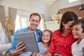 Keeping the family entertained. smiling parents sitting with their young son and daughter on their living room sofa at Royalty Free Stock Photo