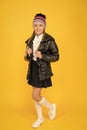 Keeping fashion and cosy. Little girl schoolchild in cozy fashion outfit on yellow background. Autumn look of small