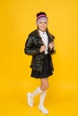 Keeping fashion and cosy. Little girl schoolchild in cozy fashion outfit on yellow background. Autumn look of small