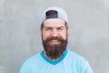 Keeping hair healthy. Happy hipster with shaped beard and styled hair wearing baseball cap. Bearded man smiling with