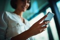 Keeping her business contacts close at hand. a young businesswoman using a mobile phone in a modern office.