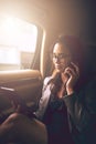 Keeping her business moving forward. Shot of a young businesswoman talking on a phone while using a digital tablet in Royalty Free Stock Photo