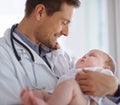 Keeping her happy. a handsome male doctor holding a baby. Royalty Free Stock Photo