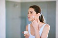 Keeping her skin clean and smooth. An attractive young woman applying cream to her face. Royalty Free Stock Photo