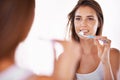 Keeping her teeth bright and white. A gorgeous young brunette brushing her teeth in the morning.