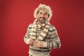 Keeping him warm. A winter ensemble protects him from cold. Bearded man accessorizing sweater with hat and scarf. Mature Royalty Free Stock Photo