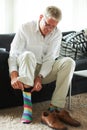 Keeping his fun side covered up. a senior man putting on colourful socks and loafers. Royalty Free Stock Photo