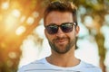 Keeping his look cool for those hot days. Portrait of a handsome young man wearing sunglasses on a summers day outdoors. Royalty Free Stock Photo
