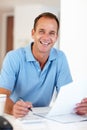 Keeping it professional at home. Portrait of a mature businessman sitting at a desk doing his paperwork. Royalty Free Stock Photo