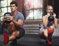 Keeping pushing each other further. two people working out with kettlebells in a gym. Royalty Free Stock Photo