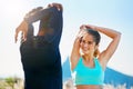 Keeping in shape as a couple. a sporty young couple stretching before a run outside.