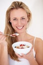 Keeping in shape. A beautiful woman enjoying a bowl of fruit and yogurt. Royalty Free Stock Photo