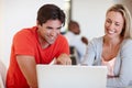 Keeping things casual in the office. two business colleagues laughing while using a laptop in an informal office. Royalty Free Stock Photo