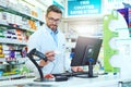 Keeping track of every package. a handsome mature male pharmacist working in a pharmacy. Royalty Free Stock Photo