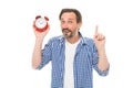 Keeping track of time. Mature timekeeper with analog clock pointing finger up. Mature man holding alarm clock. Bearded