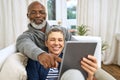 Keeping up with the times. an affectionate senior couple using a tablet while relaxing on the sofa at home. Royalty Free Stock Photo