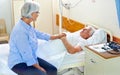 Keeping watch in his time of need. a senior woman comforting her sick husband who is lying in a hospital bed. Royalty Free Stock Photo