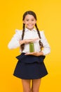 Keeping you energetic. Happy energetic schoolchild holding juice bottle on yellow background. Little girl with long hair