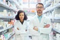 Keeping you well is what we do. Portrait of a confident mature man and young woman working together in a pharmacy. Royalty Free Stock Photo