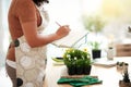 She keeps tabs on all of her plants. an unrecognizable young female botanist making notes while working in her florist.