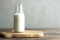 Kefir, ayran, homemade yogurt in a glass bottle stands on a wooden board on a rustic wooden table. Horizontal orientation.