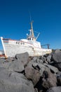 Keflavik, Iceland - July 11, 2023: The shipwreck fishing boat Baldur (1961) is aground on rocks on a sunny day