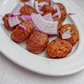 `keftedes` fried meatballs with onion, traditional Greek plate close up.