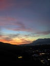 Colorful sunset sky over mountain valley and village lights Royalty Free Stock Photo