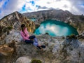 Kelimutu - A girl admiring turquoise coloured volcanic lakes