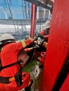 Marine crew with full PPE connect cargo hose for jack up rig