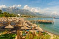 KEMER, TURKEY: Paradise scenery on the pier, umbrellas and sun loungers on the beach and mountains on a sunny day.