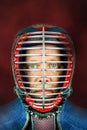 Kendo - Close up portrait of kendoka with helmet. Studio shot with red background. Royalty Free Stock Photo