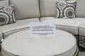 CDC guidelines and recommendations sign for people not to congregate on patio furniture couch section at Costco store during Covid