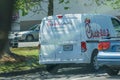 Young youthful fast food worker working at Chick-fil-a drive through amidst cars tak take orders with tablet