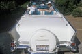 Kenny Kragen and wife in a white 1957 Chevrolet in a Beverly Hills Car Show in Los Angeles, CA