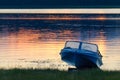 Kenozersky National Park, Russia. An old blue aluminum motorboat called `Kazanka` on the lake shore at sunset. Blue boat on the