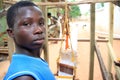 African boy in his outdoor cloth weaving shop