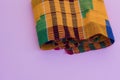 Close up shot of kente cloth against colourful background