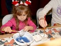 KENTSHIN, POLAND. A five-year-old girl paints a tree toy. Children `s master class in the workshop