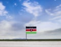 Kenya flag with vast meadow and blue sky behind it. Royalty Free Stock Photo
