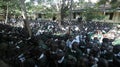 KENYA, KISUMU - MAY 23, 2017: Big crowd of African children in uniform sitting on a ground outside near school.