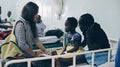 KENYA, KISUMU - MAY 20, 2017: Group of caucasian people holding little African childe on hands. Volunteers in hospital.