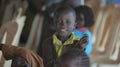 KENYA, KISUMU - MAY 23, 2017: Portrait of happy african boy sitting inside with group of children and dancing, smiling.