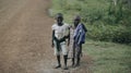 KENYA, KISUMU - MAY 20, 2017: View through leafs of african girls playing with tires on the road. Kids having fun