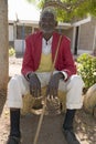 A Kenyan man sits with red jacket on at the Pepo La Tumaini Jangwani, HIV/AIDS Community Rehabilitation Program, Orphanage &