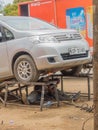 Kenyan mechanic welding under car in street