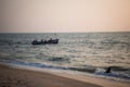 Indian fishermen launch a traditional wooden boat into the sea Royalty Free Stock Photo