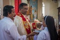 Bride, groom, family, and friends attending the Catholic wedding ceremony. Religious celebration at church in Kerala province in Royalty Free Stock Photo